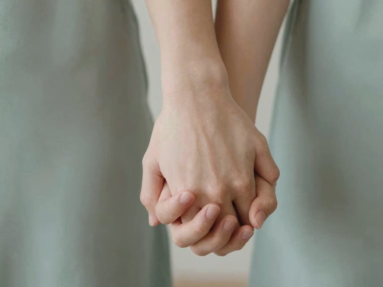 Close-up of a couple's hands gently intertwined, soft focus, warm lighting, conveying intimacy and connection, natural daylight.