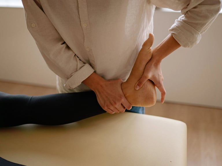 Une femme est allongée sur une table de massage, tandis qu'un thérapeute lui prodigue des soins.