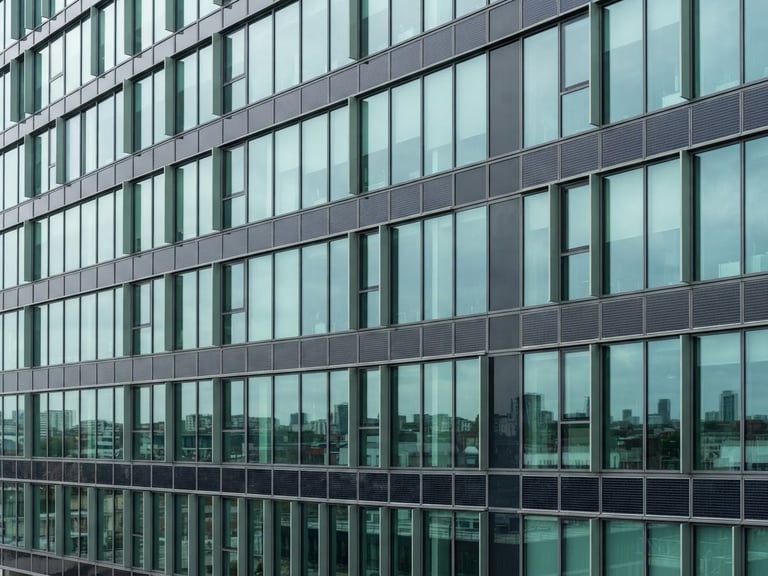 Clean architectural detail of a modern energy-efficient corporate building facade with integrated solar panels, sharp glass lines, bright overcast daylight, cool teal and sage reflections.