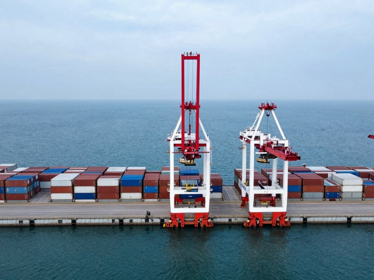 High-angle architectural drone photo of a deep-water container terminal, strict symmetrical layout, cool blue and stark white tones, sharp red crane telemetry, overcast daylight.