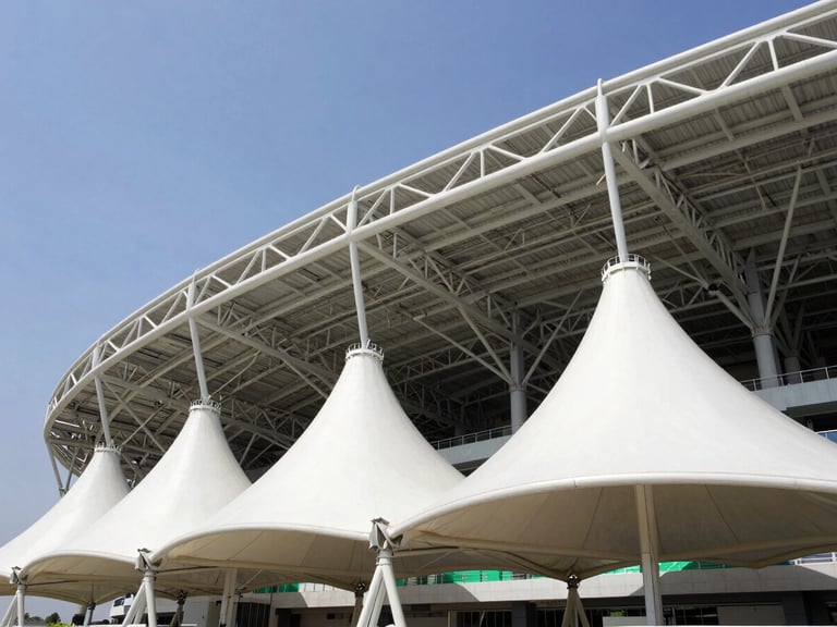 Low-angle architectural photography of a massive white tensile membrane structure over a modern stadium, bright daylight, steel trusses visible, clear sky