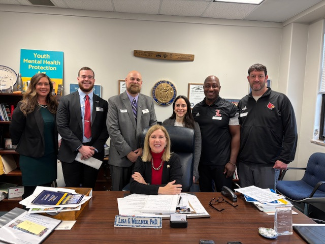 a group of people standing around a table with papers and papers