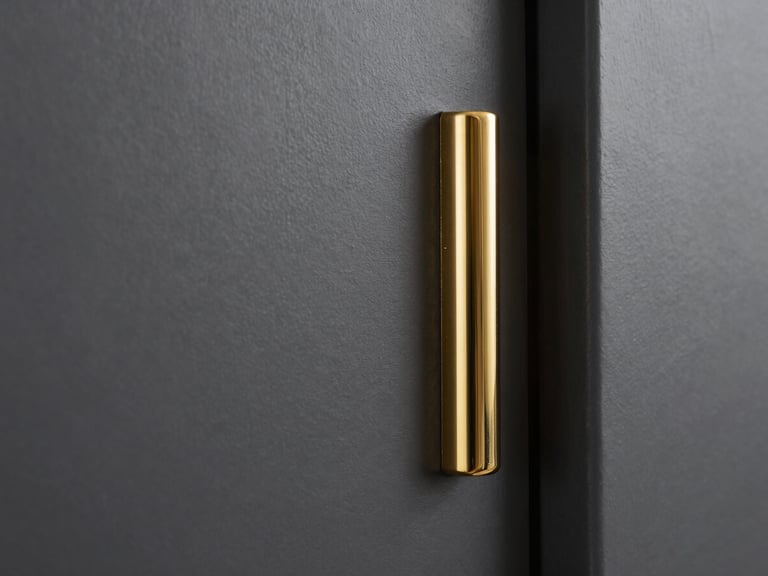 Architectural close-up of a freshly painted matte charcoal wall meeting a polished brass fixture, dramatic side-lighting highlighting the flawless paint texture and sharp gold edge.