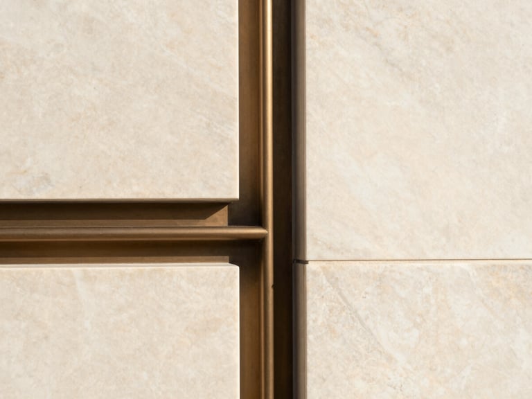 Close-up geometric architectural detail of custom millwork meeting a bookmatched marble wall perfectly, warm natural lighting, minimal aesthetic.