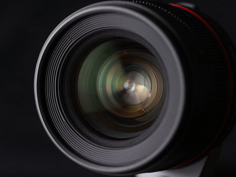 Macro shot of a high-end cinema lens, aperture blades visible, soft bokeh background, technical, cinematic, high-contrast, deep blacks.