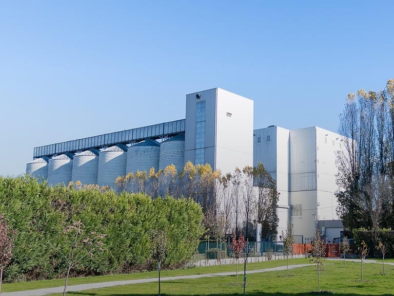Stabilimento Agugiaro & Figna a Curtarolo con silos e struttura industriale immersa nel verde.