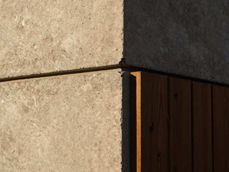 Close-up of tactile architectural detail, a perfect joint where raw concrete meets dark timber, dramatic side light, sharp focus, 35mm