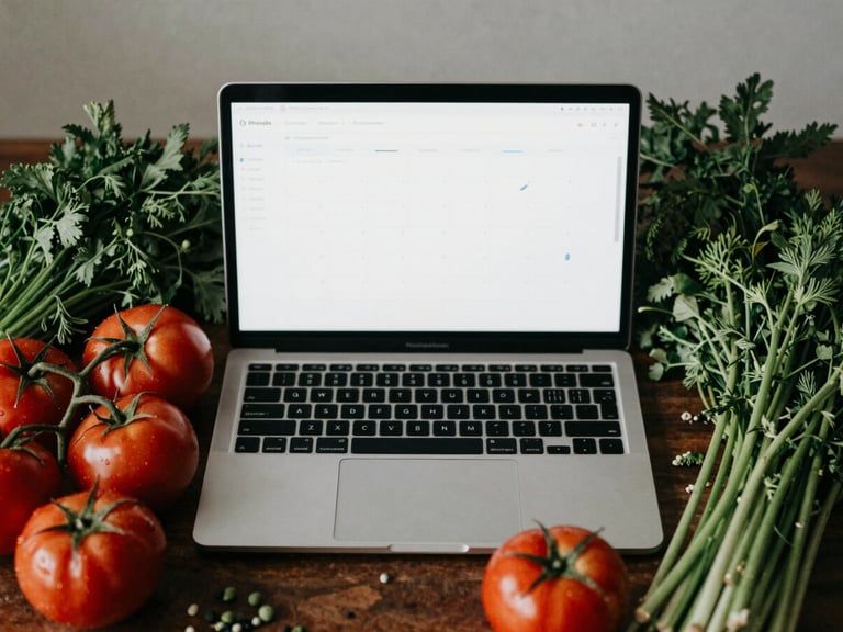 Overhead shot of a laptop displaying a social media calendar, surrounded by fresh seasonal produce like tomatoes and herbs, in soft Scandinavian daylight, matte finish.