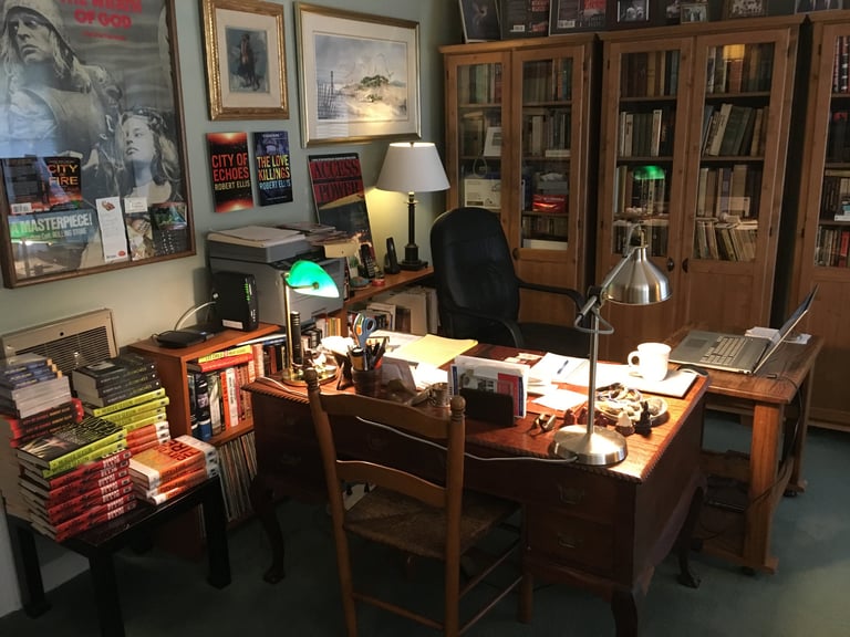 Photo of Robert Ellis's writing space with bookshelves in the background and art on the walls.