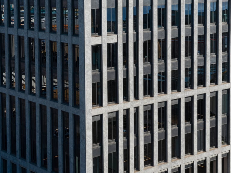 High-angle architectural view of modern corporate office building in St. Petersburg, sharp structural shadows, crisp daylight, cool blue tones.