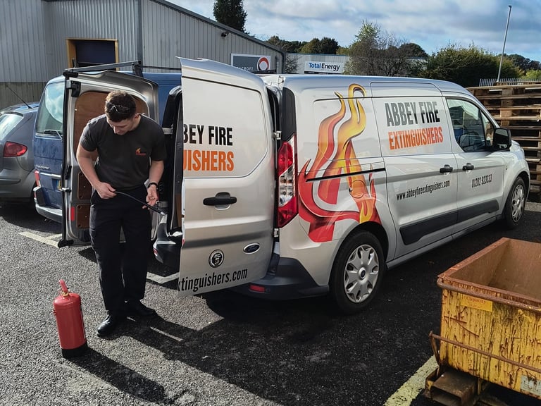 One of Abbey Fire employee's gearing up for a job with the Abbey Fire Van in the background.