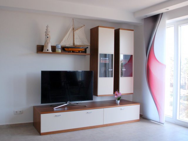 Wohnwand und Flachbild-TV: Dekoriert mit Leuchtturm, Segelboot und Kerze
