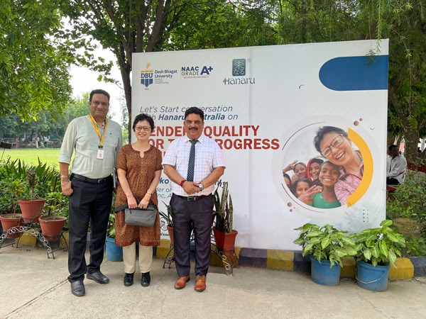3 people standing in front of advertising placard