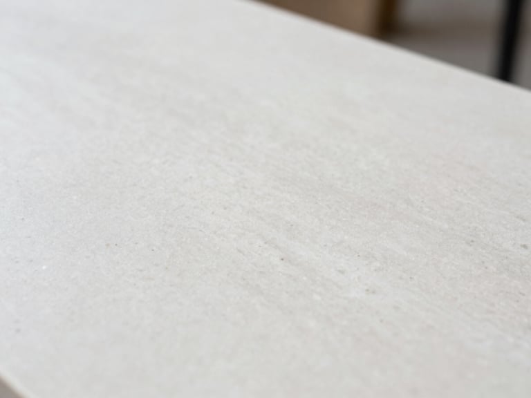 Close-up macro shot of a pure white engineered quartz slab with subtle texture, soft diffused side-light, sharp focus, 35mm lens, architectural interior photography