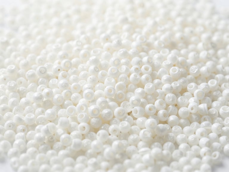 Macro shot of high-quality plastic pellets, showing uniform size and color, ready for compounding. Bright high-key laboratory lighting, sharp focus on the material, minimalist composition, 35mm.