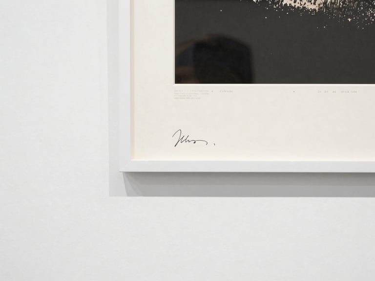 Close-up of the edge of a large-format archival pigment print, mounted on dibond, showing the artist's signature and edition number on the reverse, with a certificate of provenance.