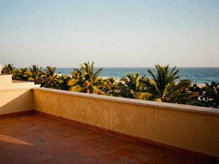 Wide candid shot of a private balcony overlooking the Arabian Sea, warm terracotta tiles, warm golden hour sunlight, 35mm film aesthetic.