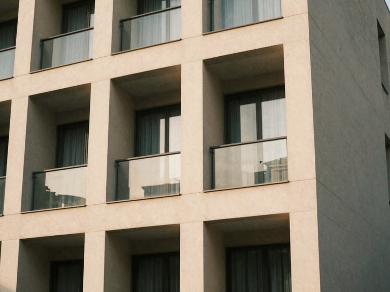 Architectural detail of a modern, clean building facade, emphasizing structure and design, soft daylight, muted earth tones, warm editorial photography.