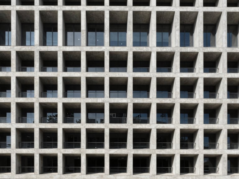 Symmetrical straight-on architectural shot of a modern concrete building facade, crisp daylight, sharp lines, structural grid pattern