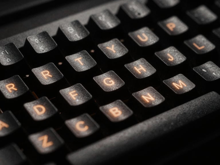 Extreme close-up of a rugged mechanical keyboard under harsh single-source amber terminal glow, deep shadows, 35mm film style