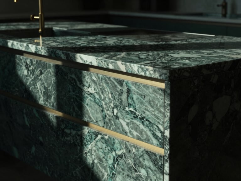 Close-up detail shot of a premium marble kitchen island with brass fittings, soft directional window light, deep shadows, minimalist styling.