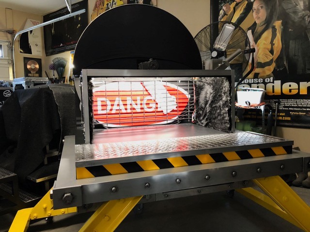 Custom stage prop with a danger sign, metal platform, and hazard stripes for a movie set.