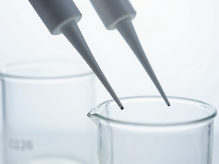 Macro close-up of sterile laboratory glassware and precision pipettes under crisp white studio light, cool tones, no human presence.
