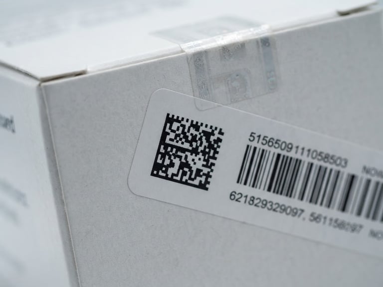 Macro close-up of a secure, sealed pharmaceutical box with barcoded tracking label, clinical white studio lighting, sharp 50mm focus