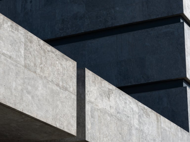 Abstract architectural detail of a modern secure government facility, sharp geometric concrete lines, cool slate and deep navy tones, high contrast, 35mm