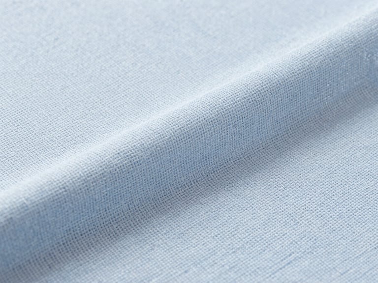 Macro photography of ice-blue cooling fabric texture, showing fine weave structure, bright clean studio lighting, high-tech textile aesthetic