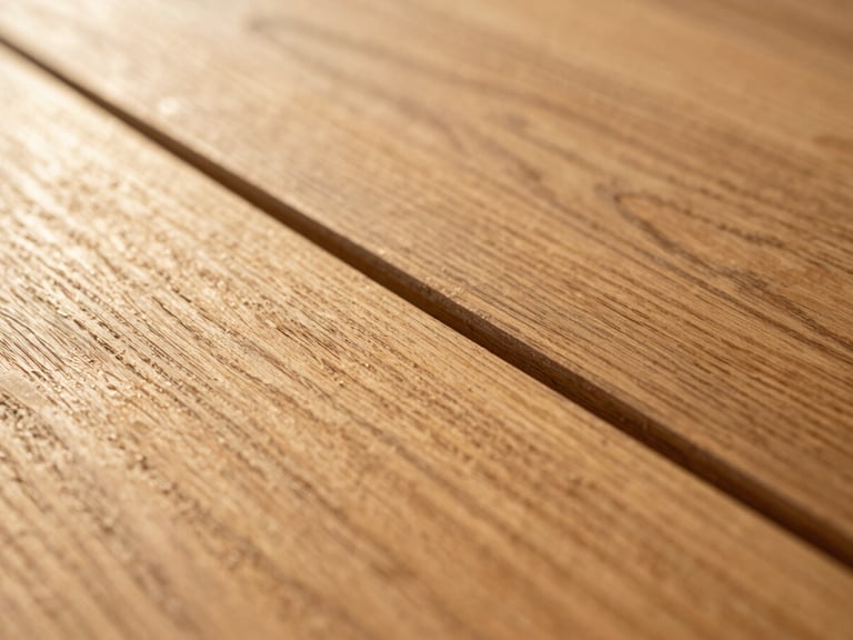 Extreme close-up of a hardwood floor seam, two planks meeting at a precise joint, grain directions subtly diverging, warm golden-hour sidelight making the wood texture three-dimensional, no context objects