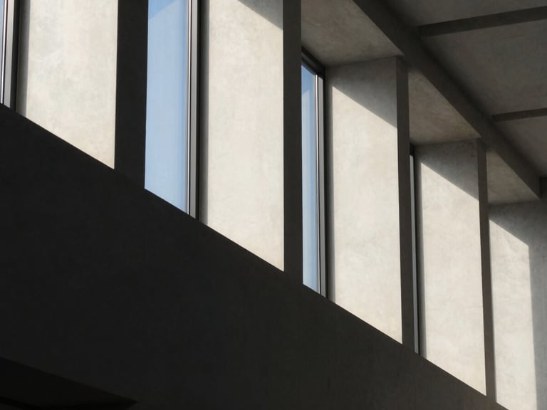 Abstract geometric concrete structure with sharp shadows, soft side lighting, elegant corporate aesthetic, 35mm lens