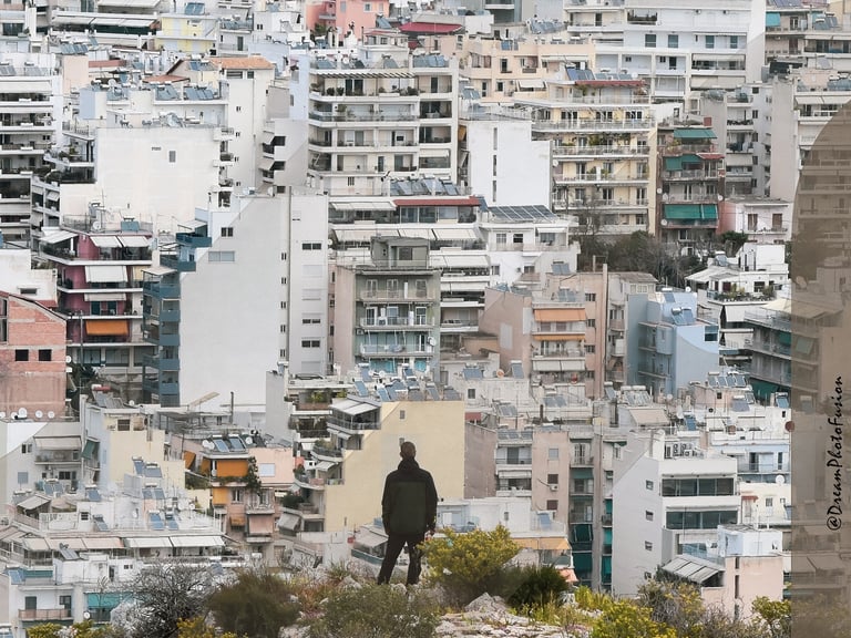 a person standing on a hill with a full city buildings in the background