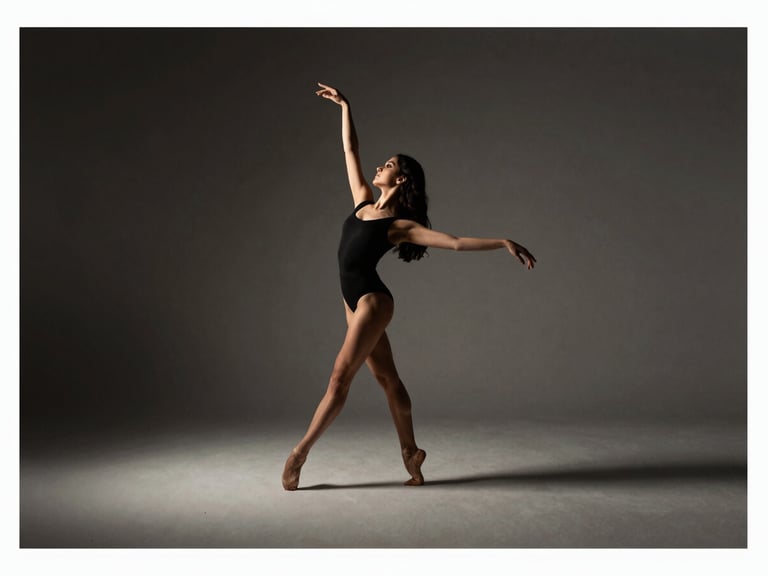 Elegant editorial dance photography, dramatic side-lit studio light, Victoria Holanda in mid-movement, sharp focus, 35mm, wide landscape crop with generous negative space
