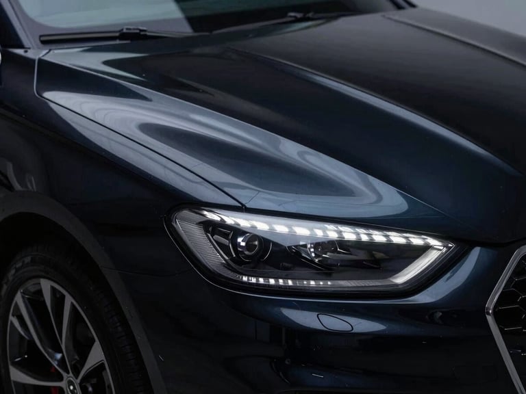 Close-up of a deep, swirl-free gloss reflection on a black luxury car's paint, under studio LED lighting, sharp details.