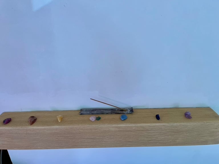 image shows 7 gemstones representing the 7 chakra colours, along with some incense