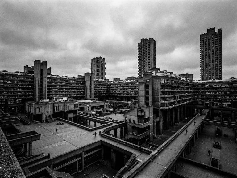 Extreme wide environmental shot of a monolithic concrete brutalist structure with sharp geometric lines, harsh shadows, under a cold, overcast sky. Focus on the scale and starkness.