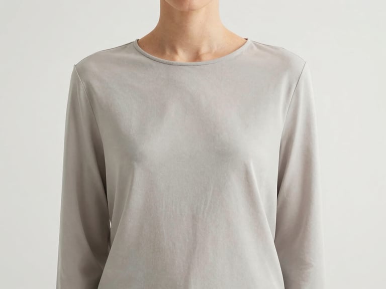 Medium shot of a model's torso, highlighting the effortless drape of a minimalist garment, soft natural daylight, clean background.