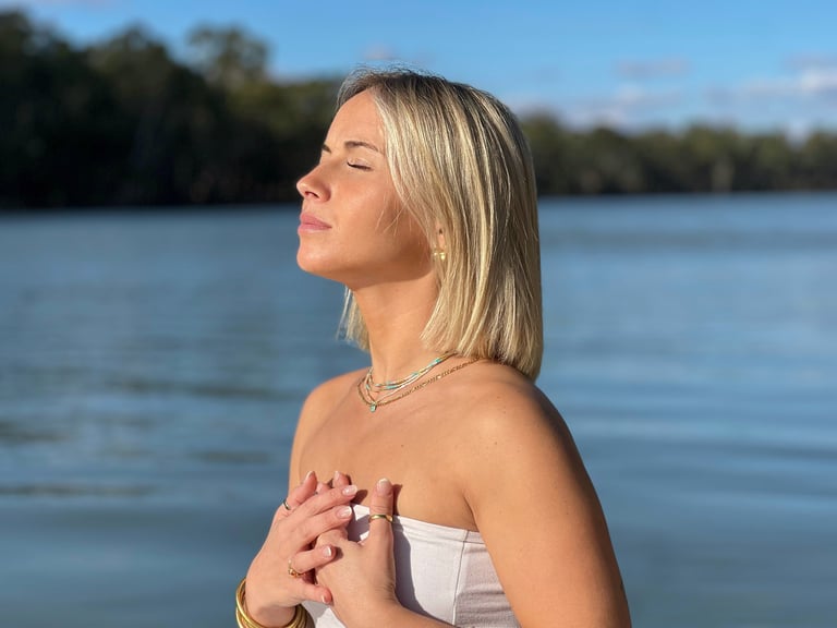 Femme de profil face à la lumière du soleil qui pratique la sophrologie
