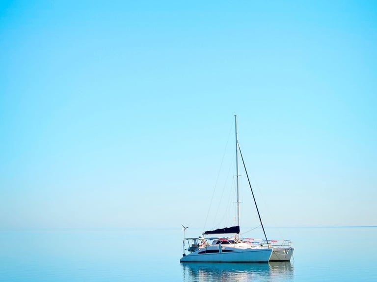 a sailboat in the water with a blue sky