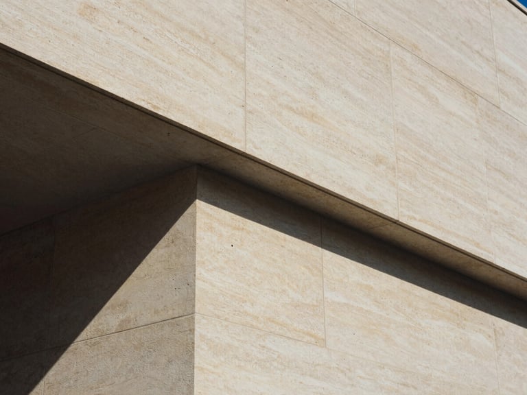Abstract close-up of sharp geometric architectural lines and structural shadows on warm stone, 35mm film style.