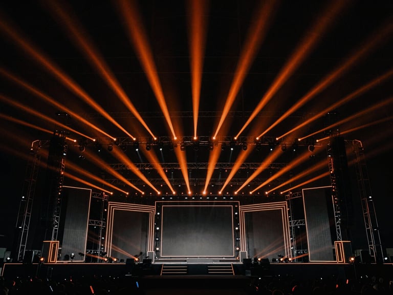 Massive event stage structure with intricate lighting setup, wide-angle view, dramatic high-contrast, deep blacks with orange spotlights, architectural lines, sharp details, 35mm