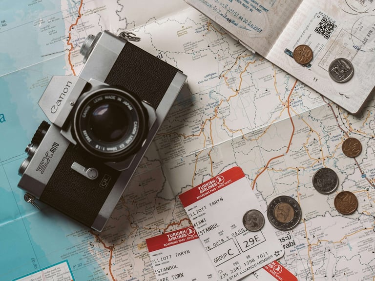 Putna karta, fotoaparat, avionske karte, putovnica i kovanice.