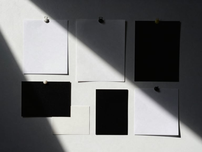 Overhead flat-lay of a creative direction mood board with deep dramatic shadows, high-contrast studio lighting, minimalist composition, 35mm film look.