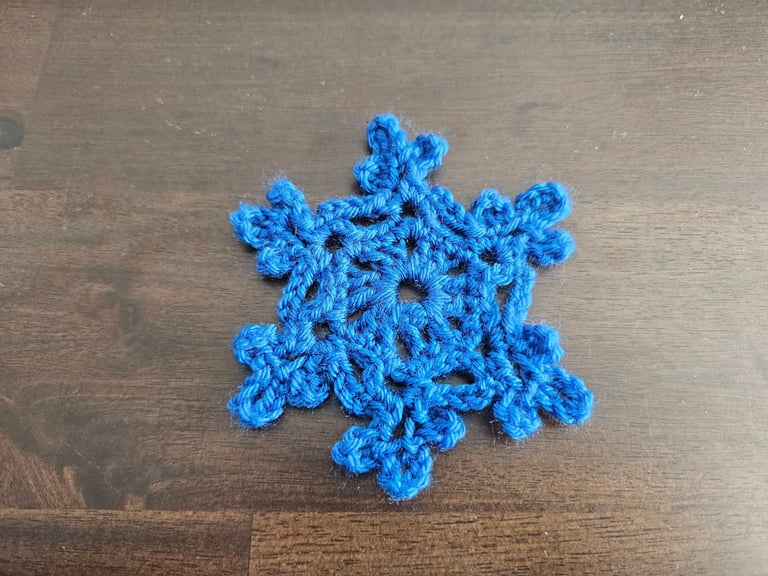 blue crochet snowflake on a wooden table