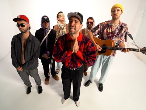 a man with a guitar and a guitar in a studio