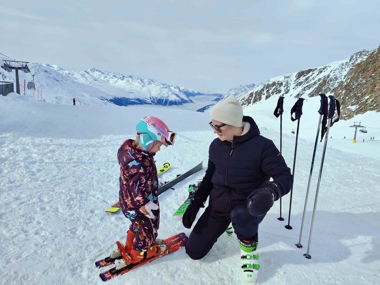 a woman and a child are standing in the snow