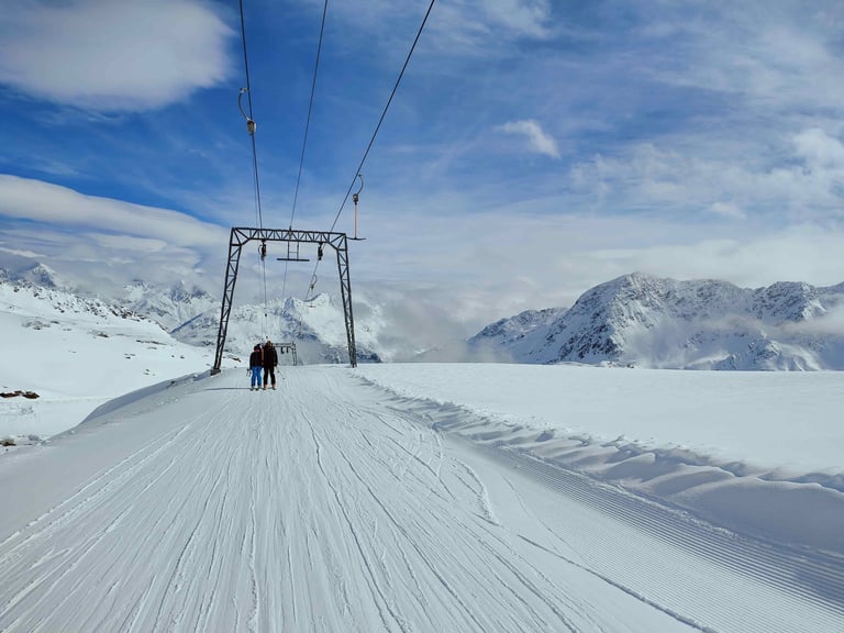 a person standing on a ski slope with a ski lift