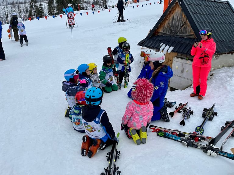 a group of children and adults in skis and snow gear