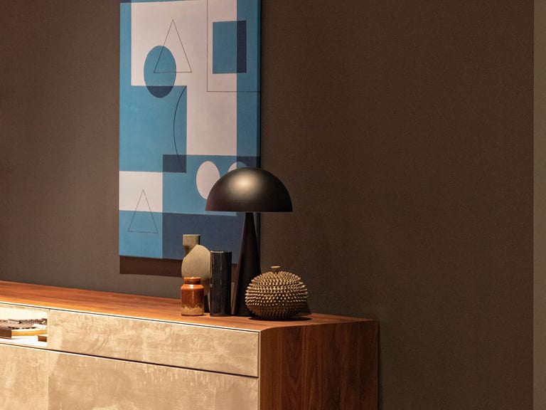 renovation done in a drawing room showcasing an antique wood table with lamp and accessories and art